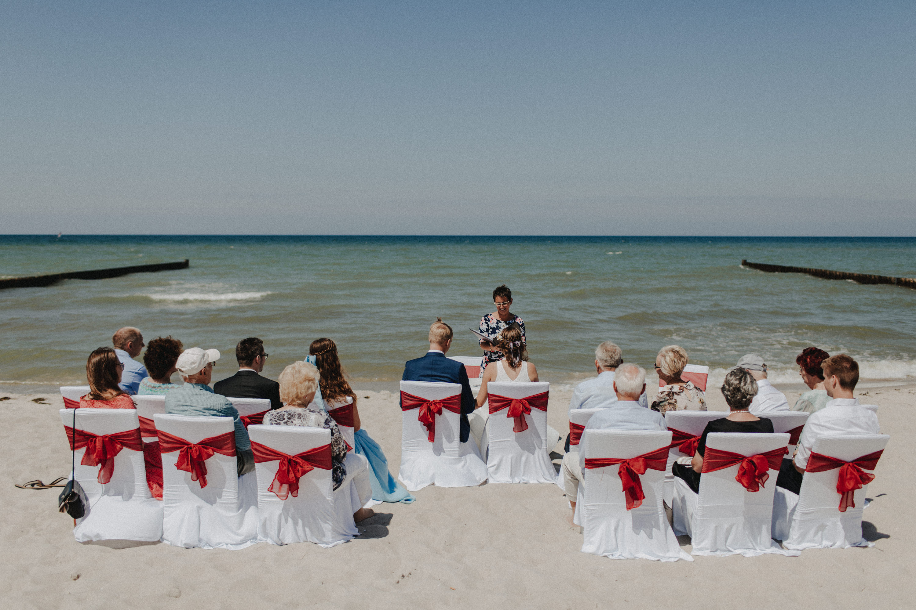 Strandhochzeit an der Ostsee. Es handelt sich um ein Foto aus einer Hochzeitsreportage, das von den beiden Hochzeitsfotografen Tom und Lia Fotografie aus Potsdam aufgenommen wurde. Die Hochzeit fand in Ahrenshoop direkt am Strand statt.