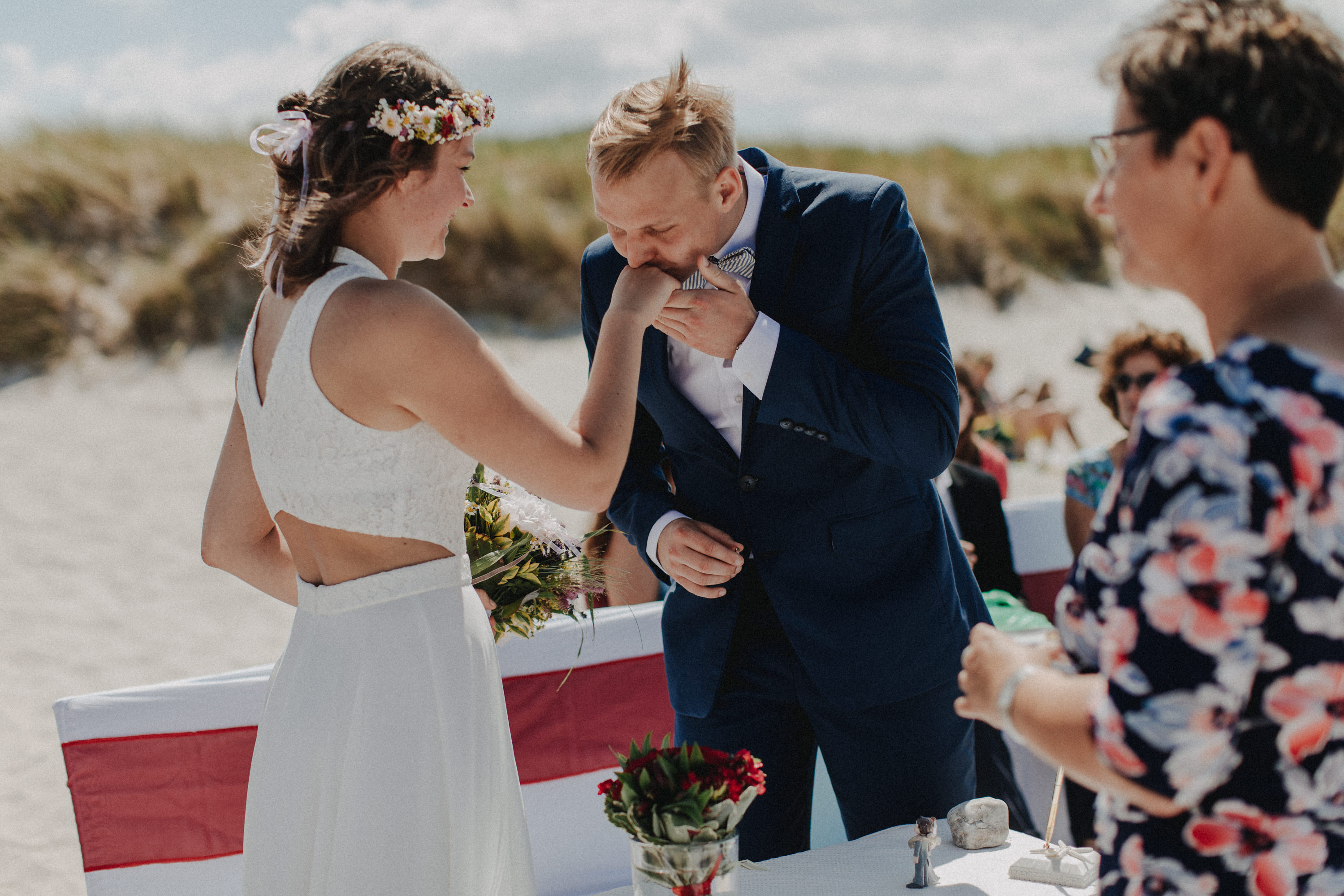 Strandhochzeit an der Ostsee. Es handelt sich um ein Foto aus einer Hochzeitsreportage, das von den beiden Hochzeitsfotografen Tom und Lia Fotografie aus Potsdam aufgenommen wurde. Die Hochzeit fand in Ahrenshoop direkt am Strand statt.