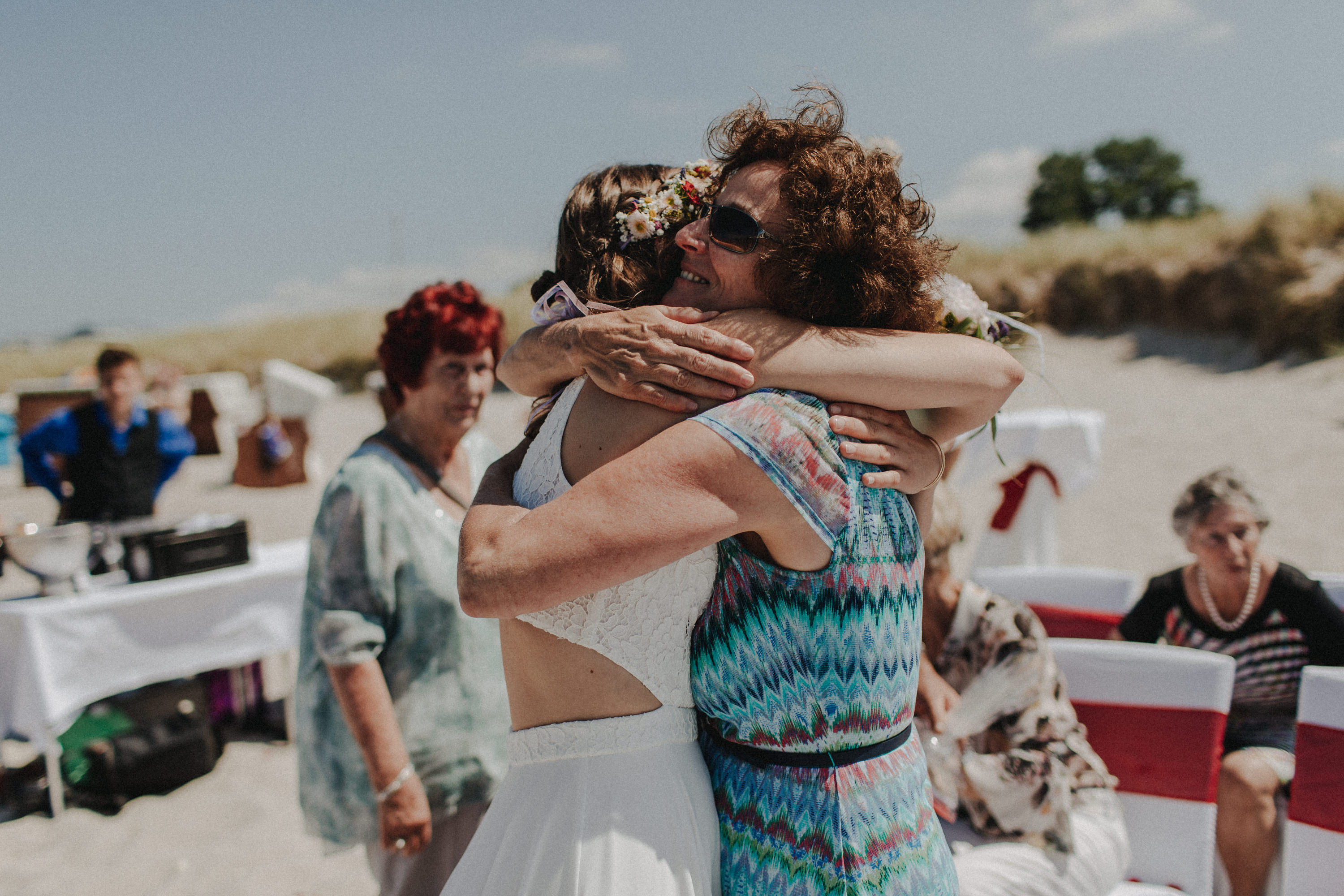 Strandhochzeit an der Ostsee. Es handelt sich um ein Foto aus einer Hochzeitsreportage, das von den beiden Hochzeitsfotografen Tom und Lia Fotografie aus Potsdam aufgenommen wurde. Die Hochzeit fand in Ahrenshoop direkt am Strand statt.