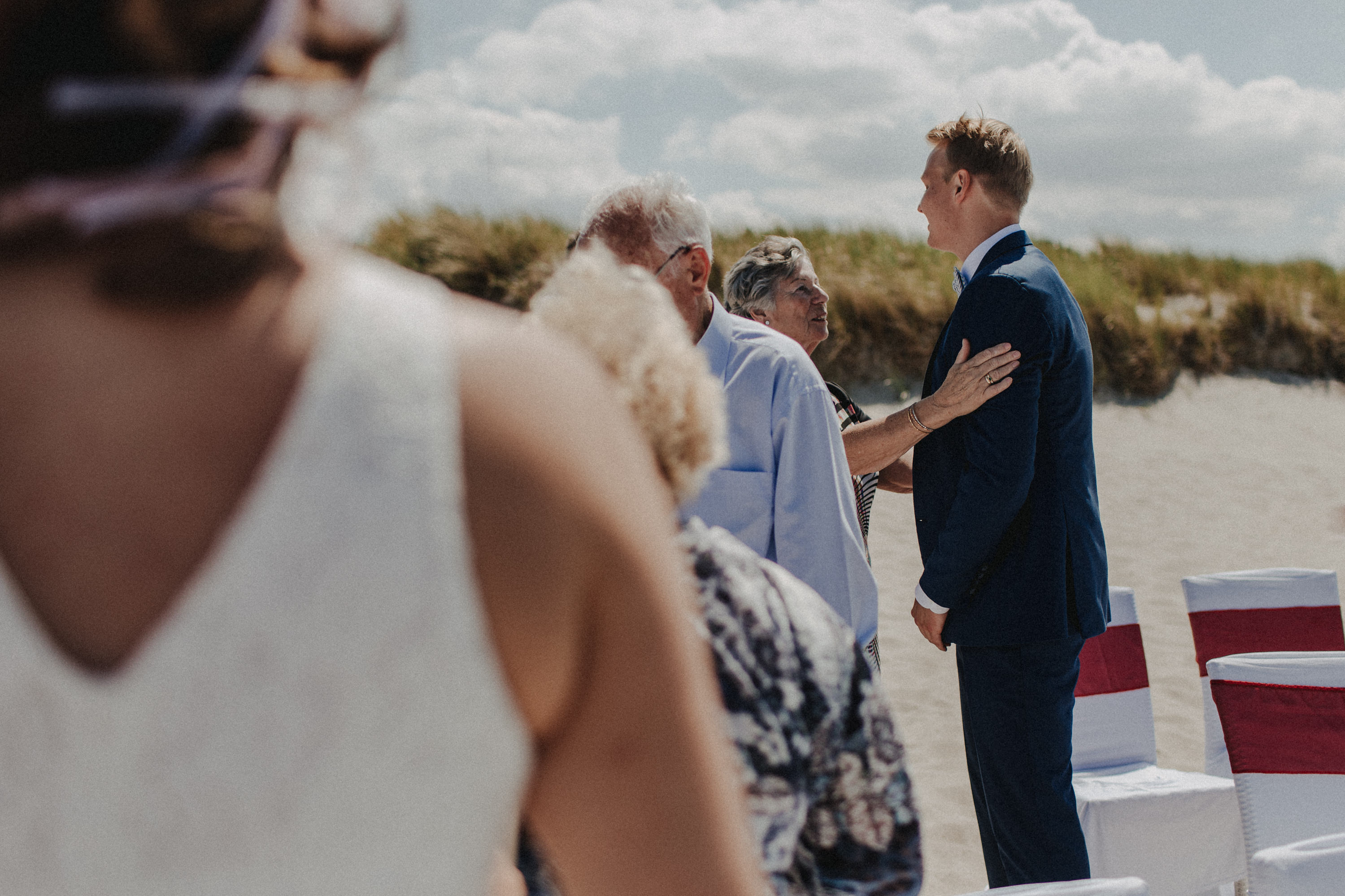 Strandhochzeit an der Ostsee. Es handelt sich um ein Foto aus einer Hochzeitsreportage, das von den beiden Hochzeitsfotografen Tom und Lia Fotografie aus Potsdam aufgenommen wurde. Die Hochzeit fand in Ahrenshoop direkt am Strand statt.