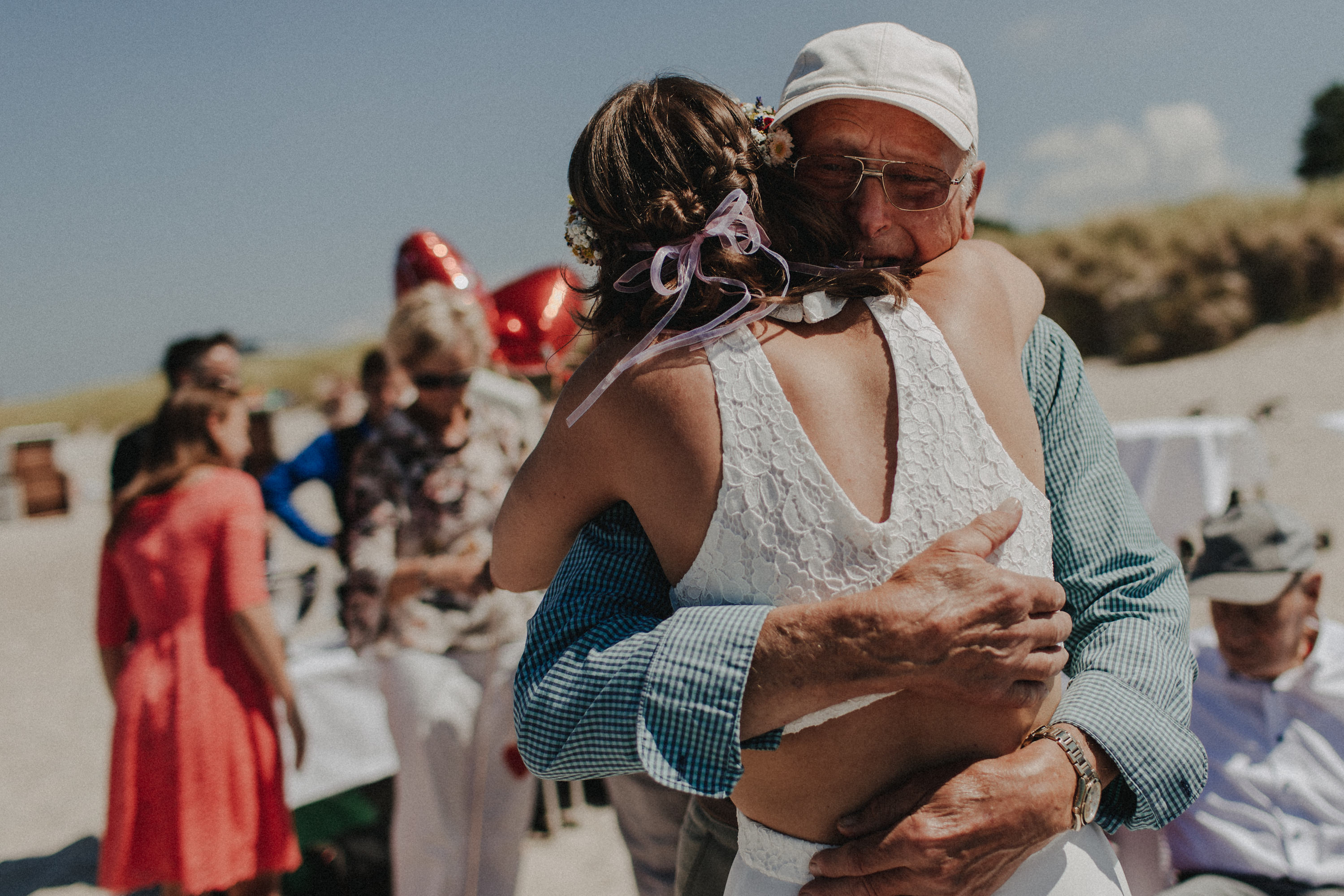 Strandhochzeit an der Ostsee. Es handelt sich um ein Foto aus einer Hochzeitsreportage, das von den beiden Hochzeitsfotografen Tom und Lia Fotografie aus Potsdam aufgenommen wurde. Die Hochzeit fand in Ahrenshoop direkt am Strand statt.