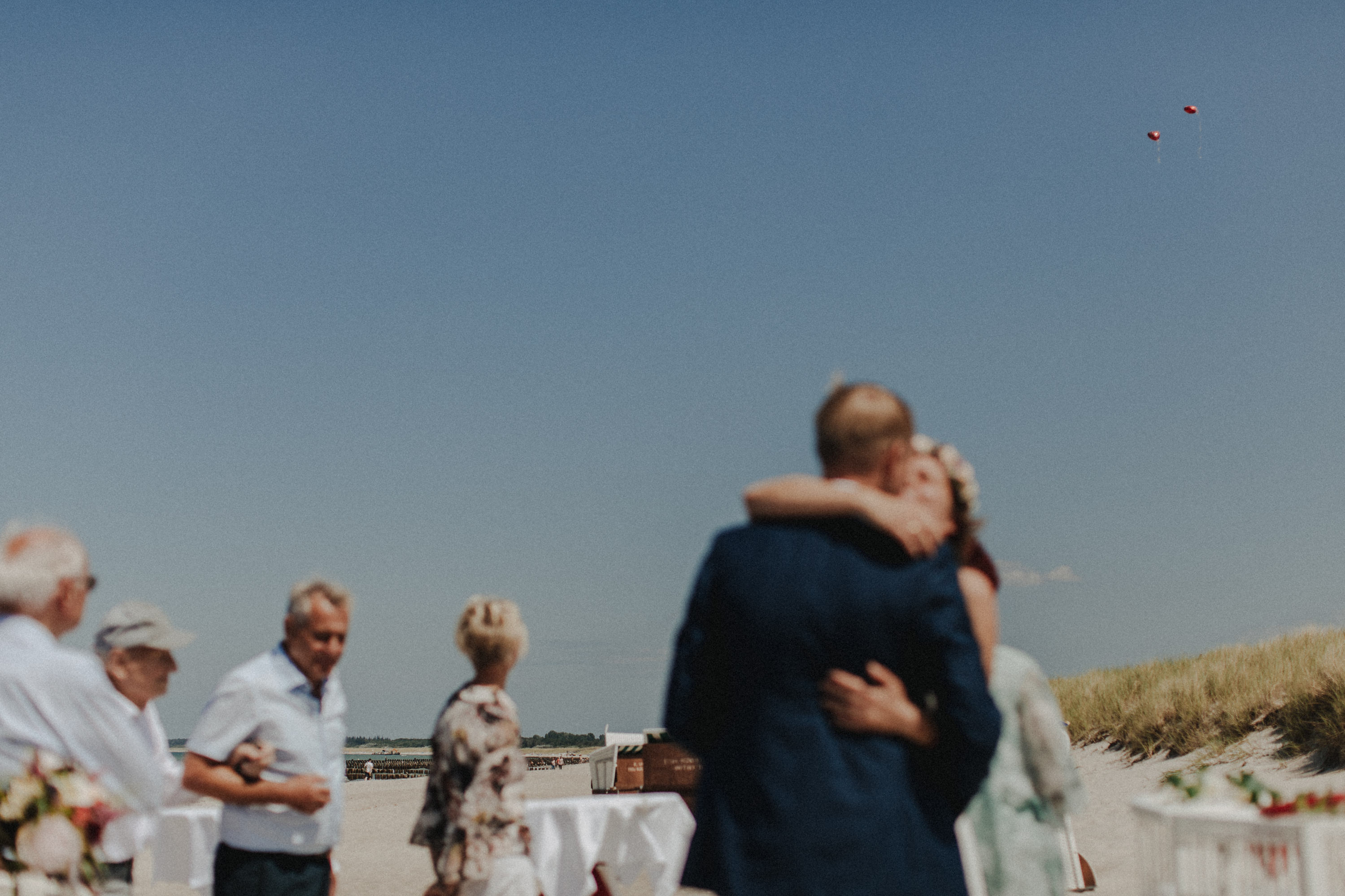 Strandhochzeit an der Ostsee. Es handelt sich um ein Foto aus einer Hochzeitsreportage, das von den beiden Hochzeitsfotografen Tom und Lia Fotografie aus Potsdam aufgenommen wurde. Die Hochzeit fand in Ahrenshoop direkt am Strand statt.