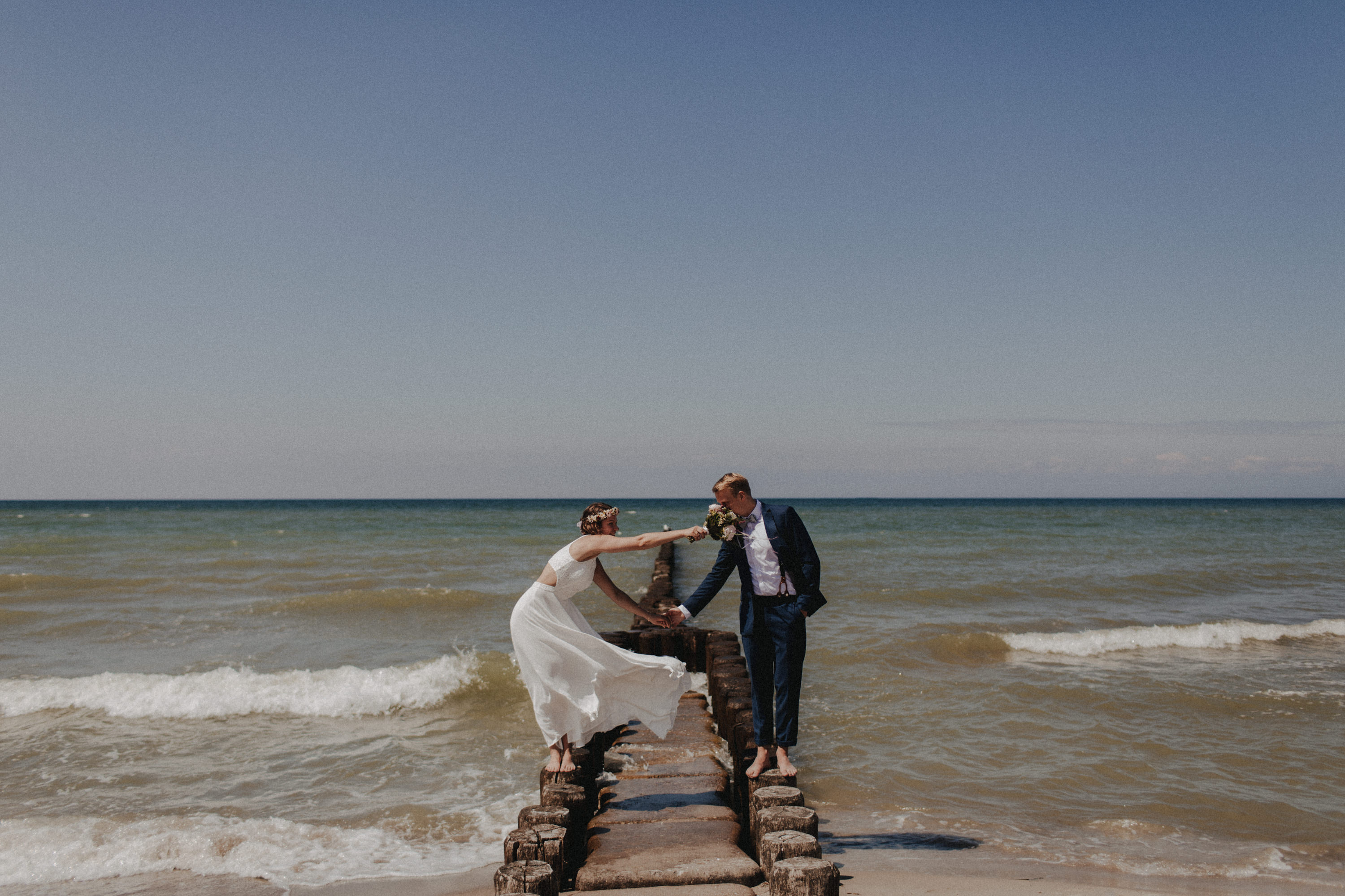 Strandhochzeit an der Ostsee. Es handelt sich um ein Foto aus einer Hochzeitsreportage, das von den beiden Hochzeitsfotografen Tom und Lia Fotografie aus Potsdam aufgenommen wurde. Die Hochzeit fand in Ahrenshoop direkt am Strand statt.