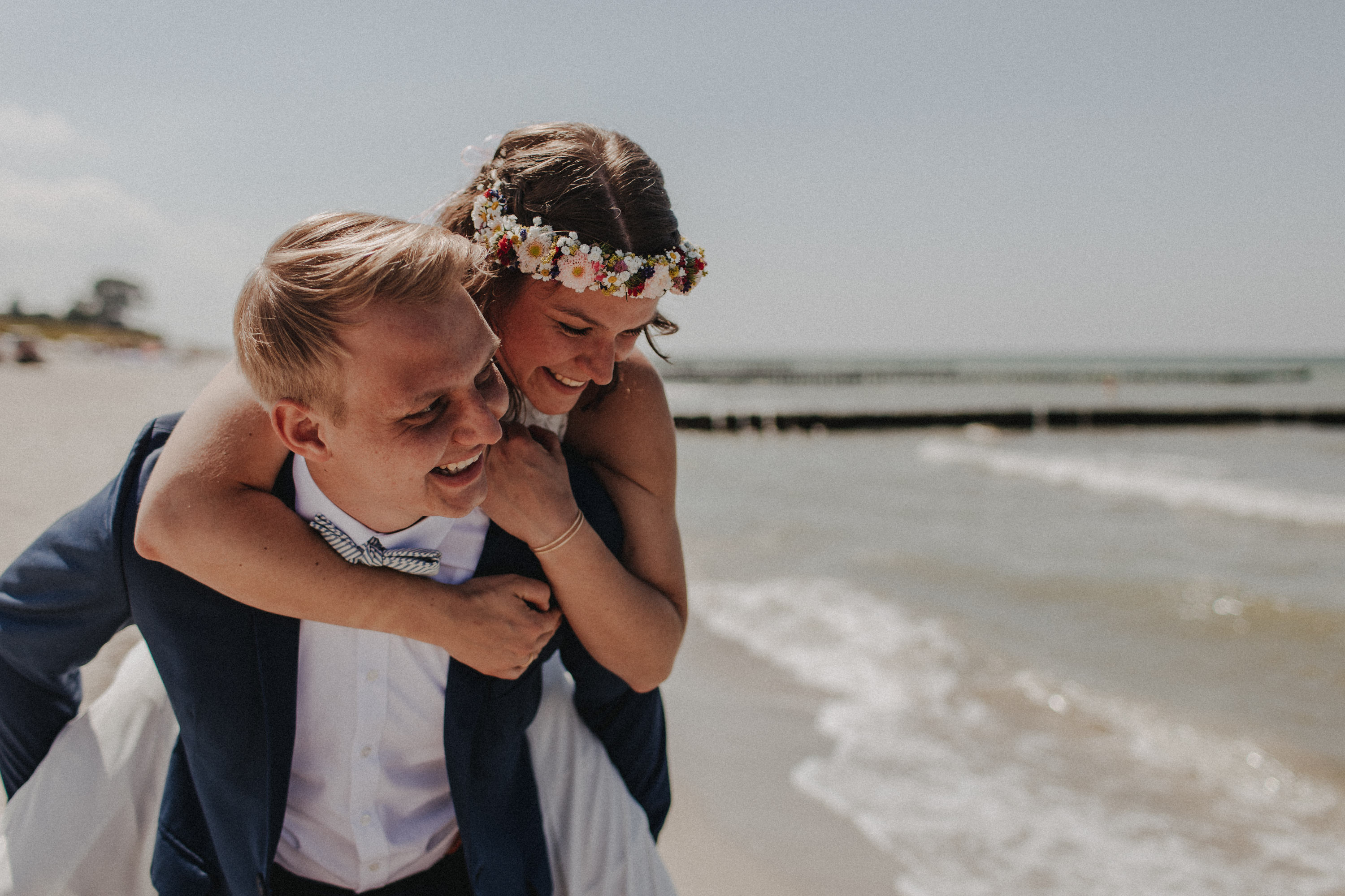 Strandhochzeit an der Ostsee. Es handelt sich um ein Foto aus einer Hochzeitsreportage, das von den beiden Hochzeitsfotografen Tom und Lia Fotografie aus Potsdam aufgenommen wurde. Die Hochzeit fand in Ahrenshoop direkt am Strand statt.