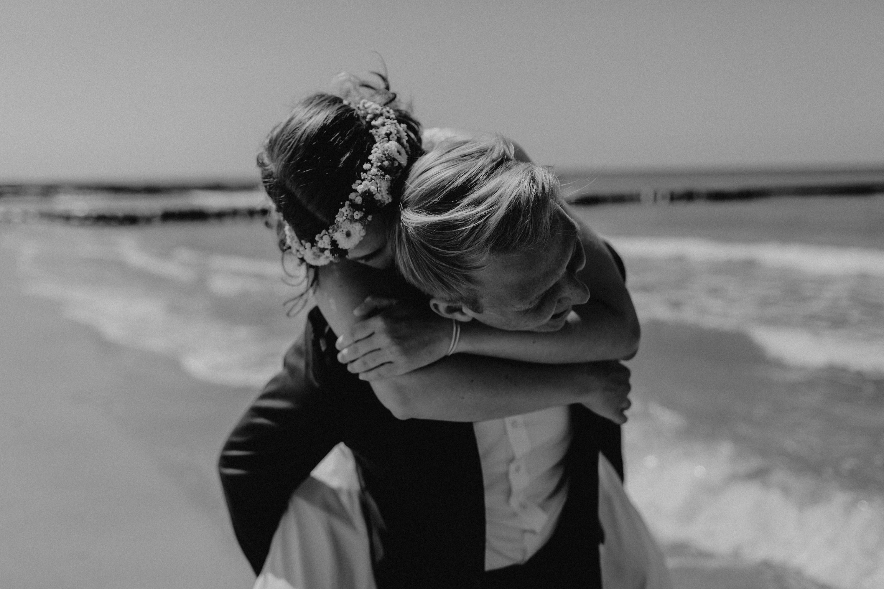 Strandhochzeit an der Ostsee. Es handelt sich um ein Foto aus einer Hochzeitsreportage, das von den beiden Hochzeitsfotografen Tom und Lia Fotografie aus Potsdam aufgenommen wurde. Die Hochzeit fand in Ahrenshoop direkt am Strand statt.