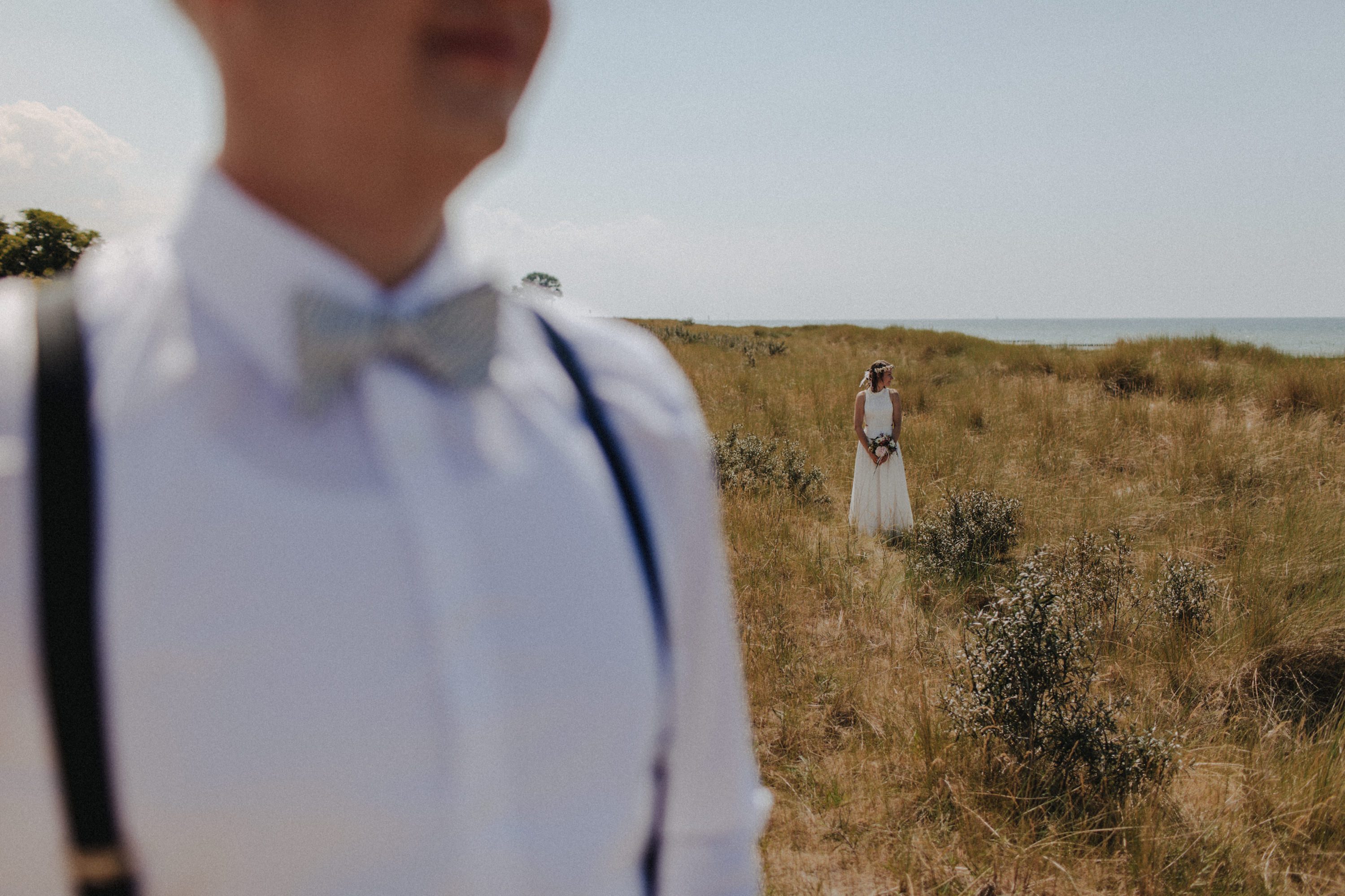 Strandhochzeit an der Ostsee. Es handelt sich um ein Foto aus einer Hochzeitsreportage, das von den beiden Hochzeitsfotografen Tom und Lia Fotografie aus Potsdam aufgenommen wurde. Die Hochzeit fand in Ahrenshoop direkt am Strand statt.