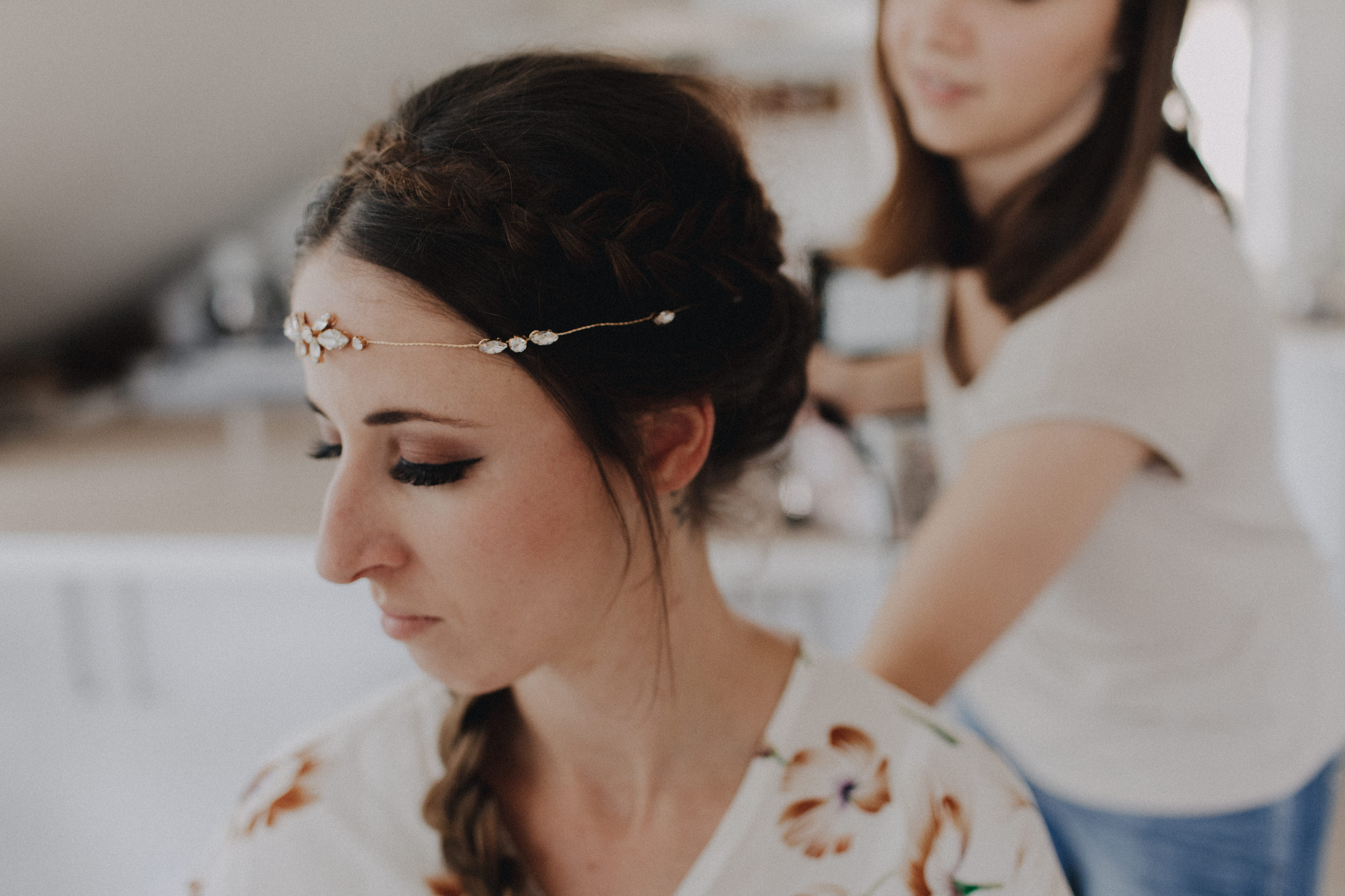 Dieses Foto ist Teil einer Hochzeitsreportage, die von den Hochzeitsfotografen Tom und Lia aus Potsdam aufgenommen wurde. Zu sehen ist die Braut, die während des Getting Readys geschminkt und angezogen wird. 