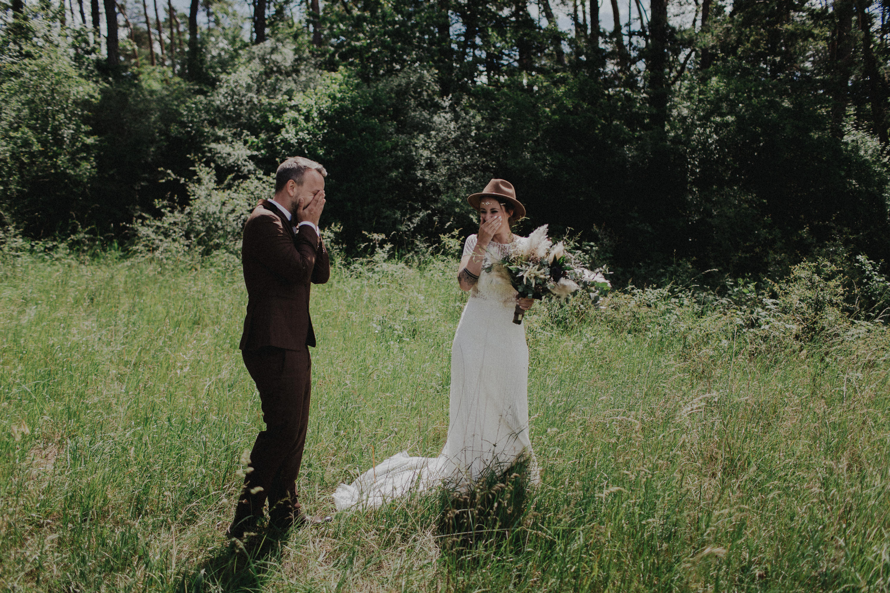 Dieses Foto ist Teil einer Hochzeitsreportage, die von den Hochzeitsfotografen Tom und Lia aus Potsdam aufgenommen wurde. Zu sehen ist das Brautpaar während des Brautpaar-Shootings in einem satt grünem Feld bei strahlendem Sonnenschein.