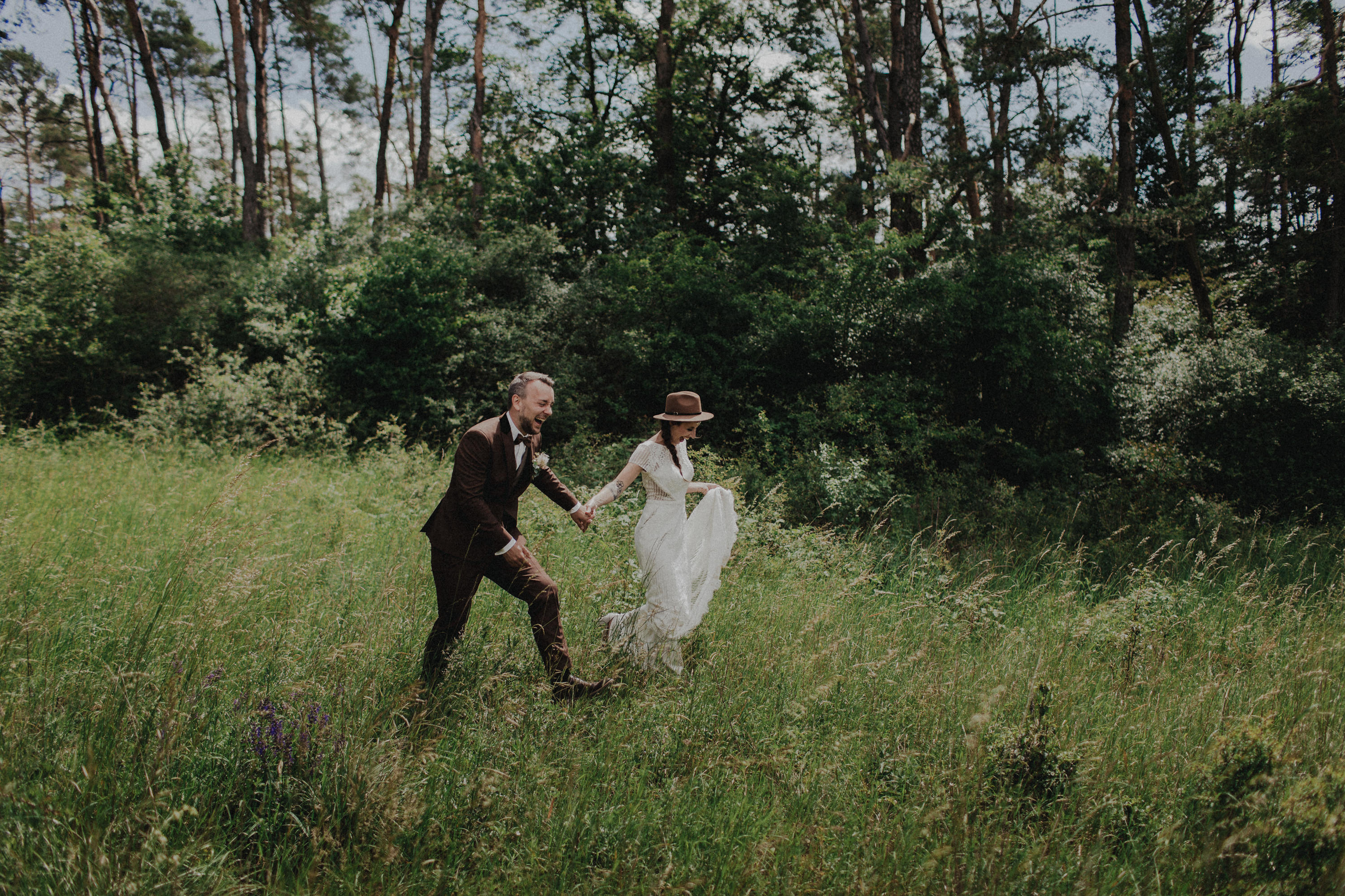 Dieses Foto ist Teil einer Hochzeitsreportage, die von den Hochzeitsfotografen Tom und Lia aus Potsdam aufgenommen wurde. Zu sehen ist das Brautpaar während des Brautpaar-Shootings in einem satt grünem Feld bei strahlendem Sonnenschein.