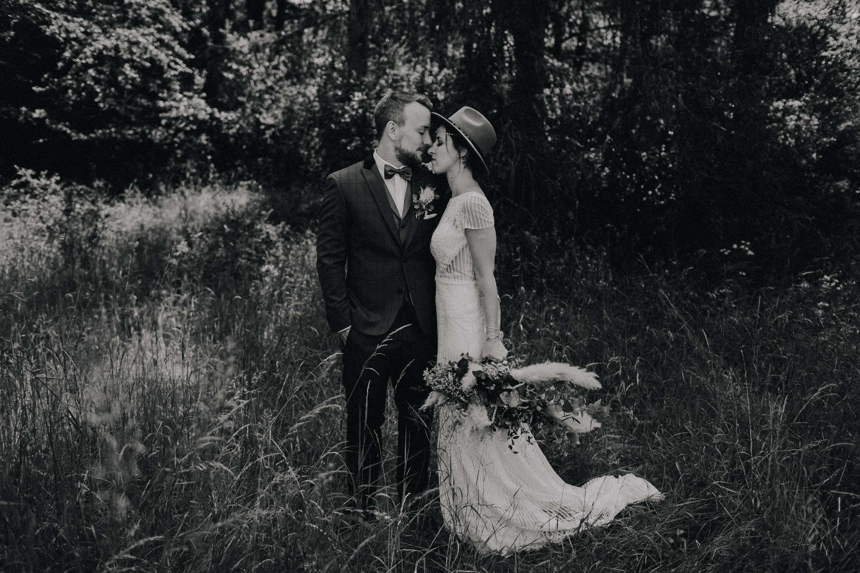 Dieses Foto ist Teil einer Hochzeitsreportage, die von den Hochzeitsfotografen Tom und Lia aus Potsdam aufgenommen wurde. Zu sehen ist das Brautpaar während des Brautpaar-Shootings in einem satt grünem Feld bei strahlendem Sonnenschein.