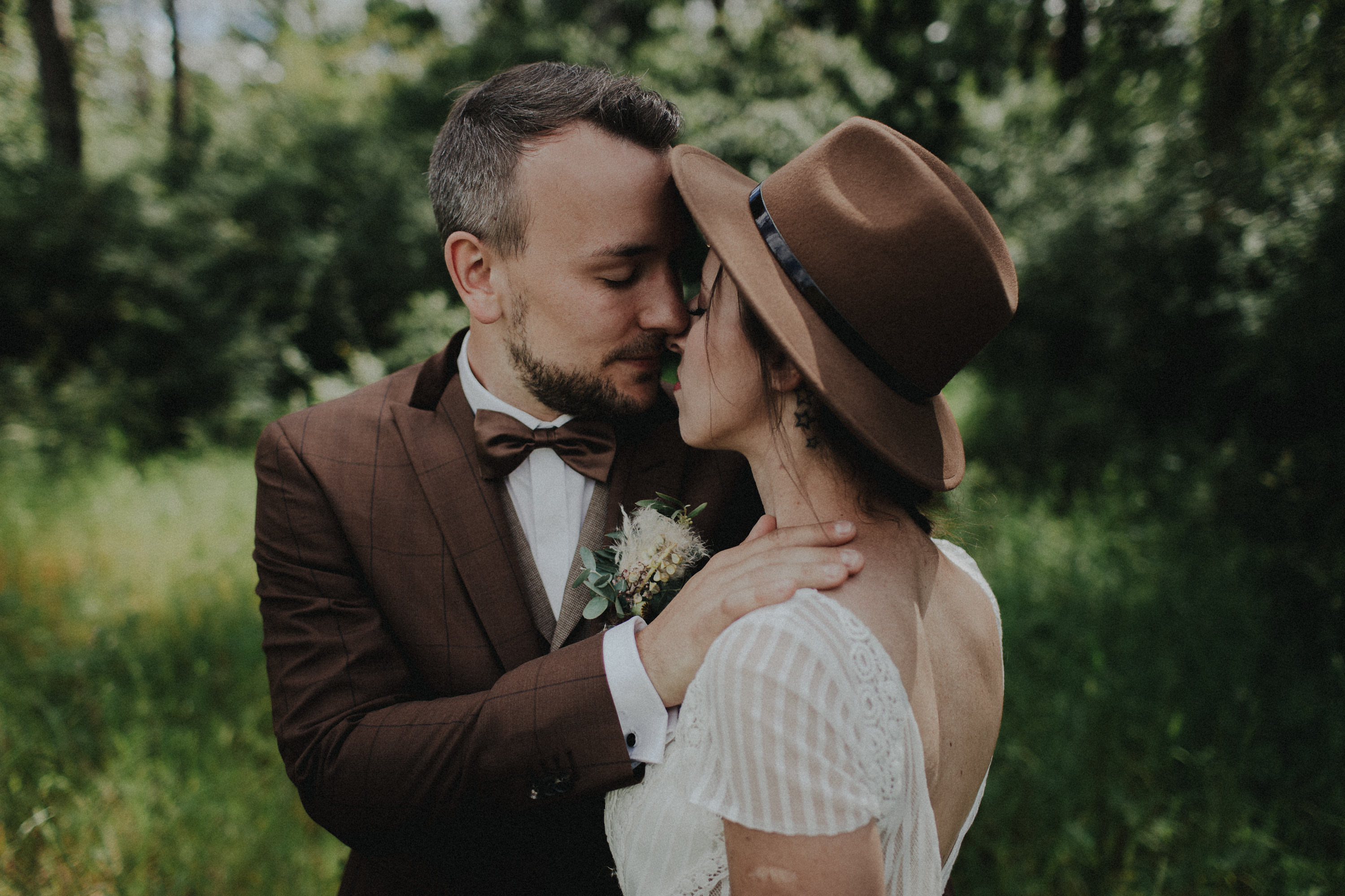 Dieses Foto ist Teil einer Hochzeitsreportage, die von den Hochzeitsfotografen Tom und Lia aus Potsdam aufgenommen wurde. Zu sehen ist das Brautpaar während des Brautpaar-Shootings in einem satt grünem Feld bei strahlendem Sonnenschein.