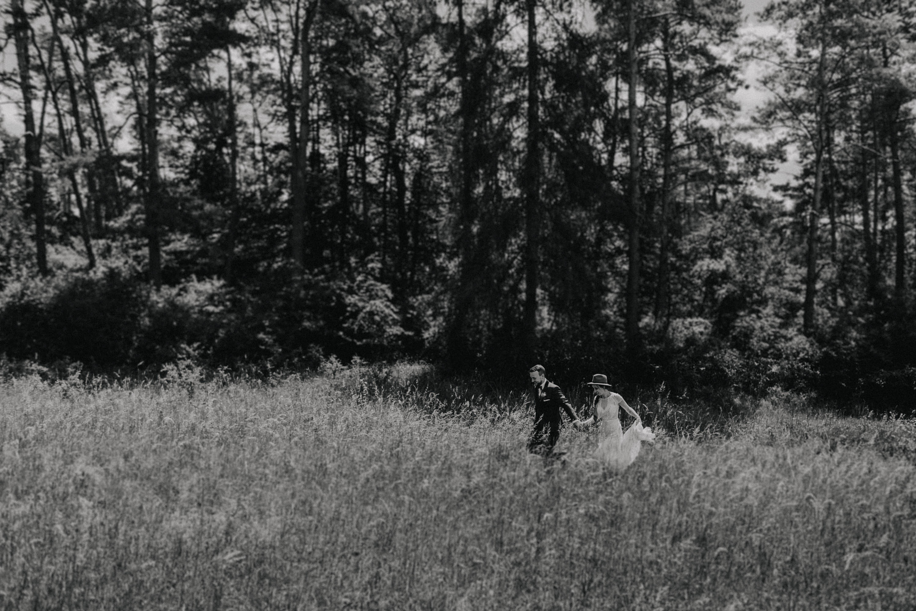 Dieses Foto ist Teil einer Hochzeitsreportage, die von den Hochzeitsfotografen Tom und Lia aus Potsdam aufgenommen wurde. Zu sehen ist das Brautpaar während des Brautpaar-Shootings in einem satt grünem Feld bei strahlendem Sonnenschein.