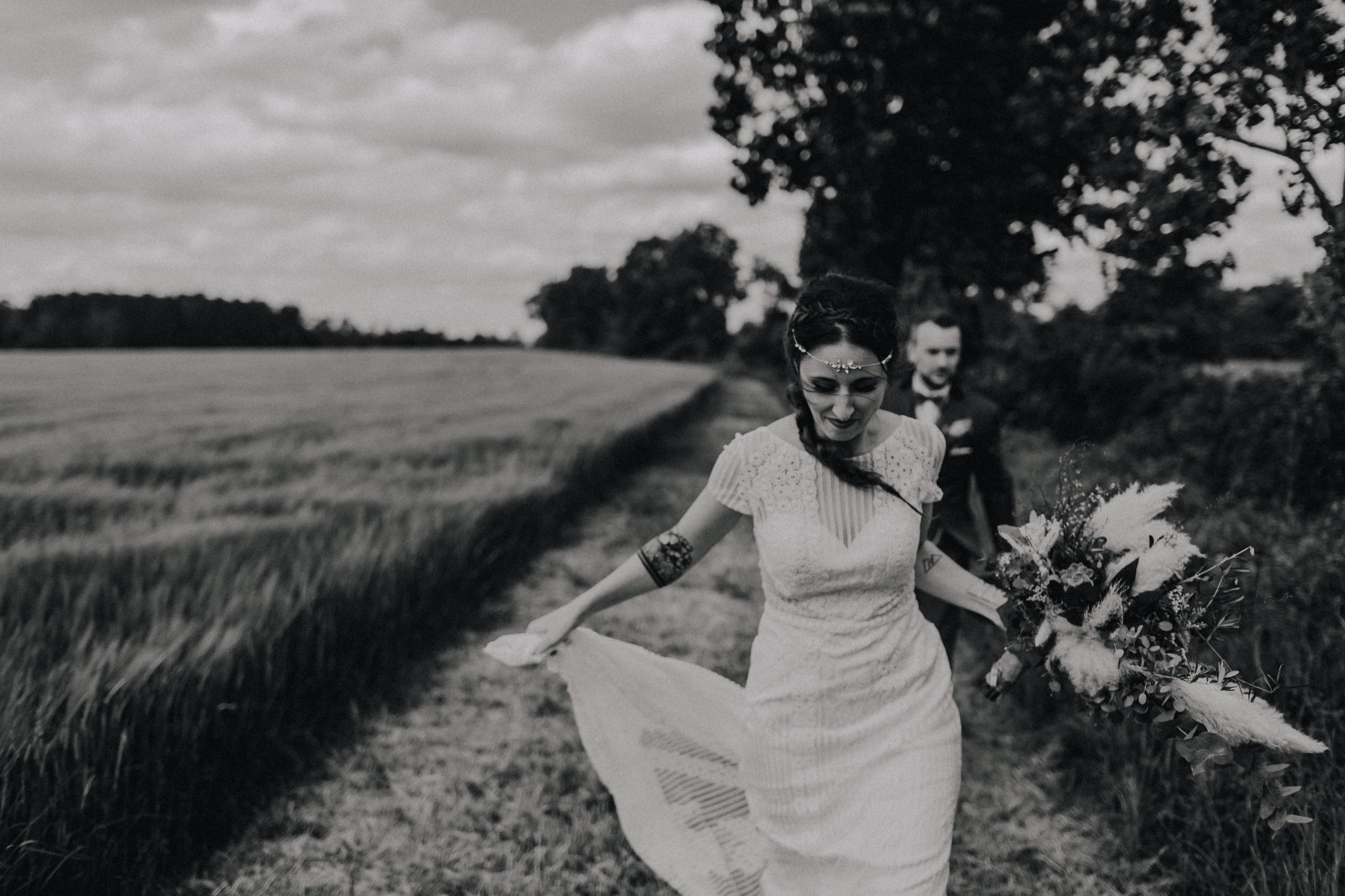 Dieses Foto ist Teil einer Hochzeitsreportage, die von den Hochzeitsfotografen Tom und Lia aus Potsdam aufgenommen wurde. Zu sehen ist das Brautpaar während des Brautpaar-Shootings in einem satt grünem Feld bei strahlendem Sonnenschein.